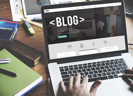 Ordenador con la palabra 'blog' en la pantalla, representando el servicio de blog corporativo.