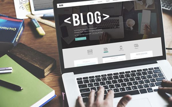 Ordenador con la palabra 'blog' en la pantalla, representando el servicio de blog corporativo.